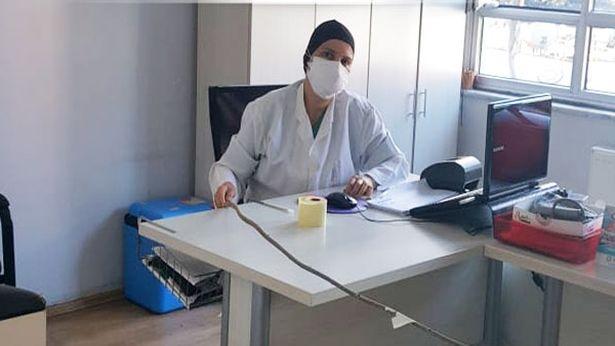 Genç doktor, hastalarla arasındaki sosyal mesafeyi fındık çubuğuyla koruyor