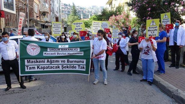 Sağlık çalışanları, maske ve sosyal mesafeye dikkat çekmek için yürüdü